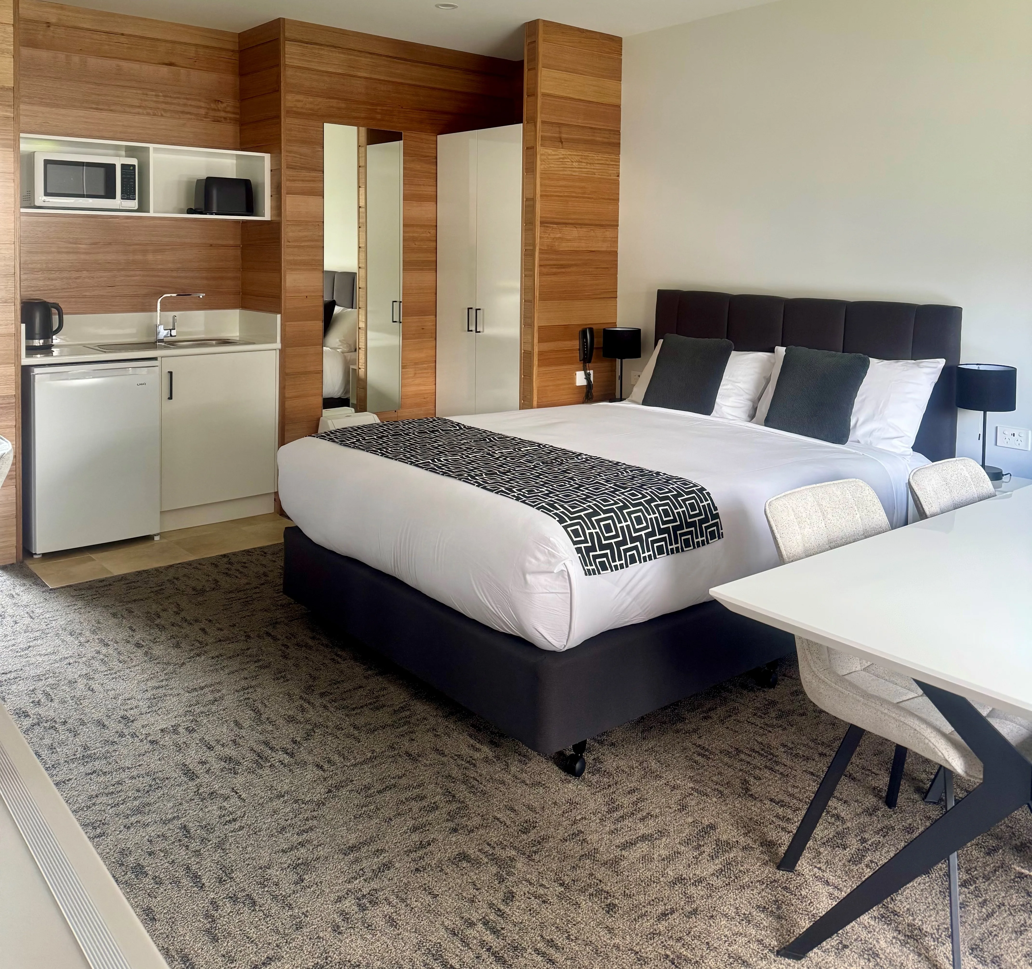 Two-bedroom motel unit with two beds and a kitchenette.