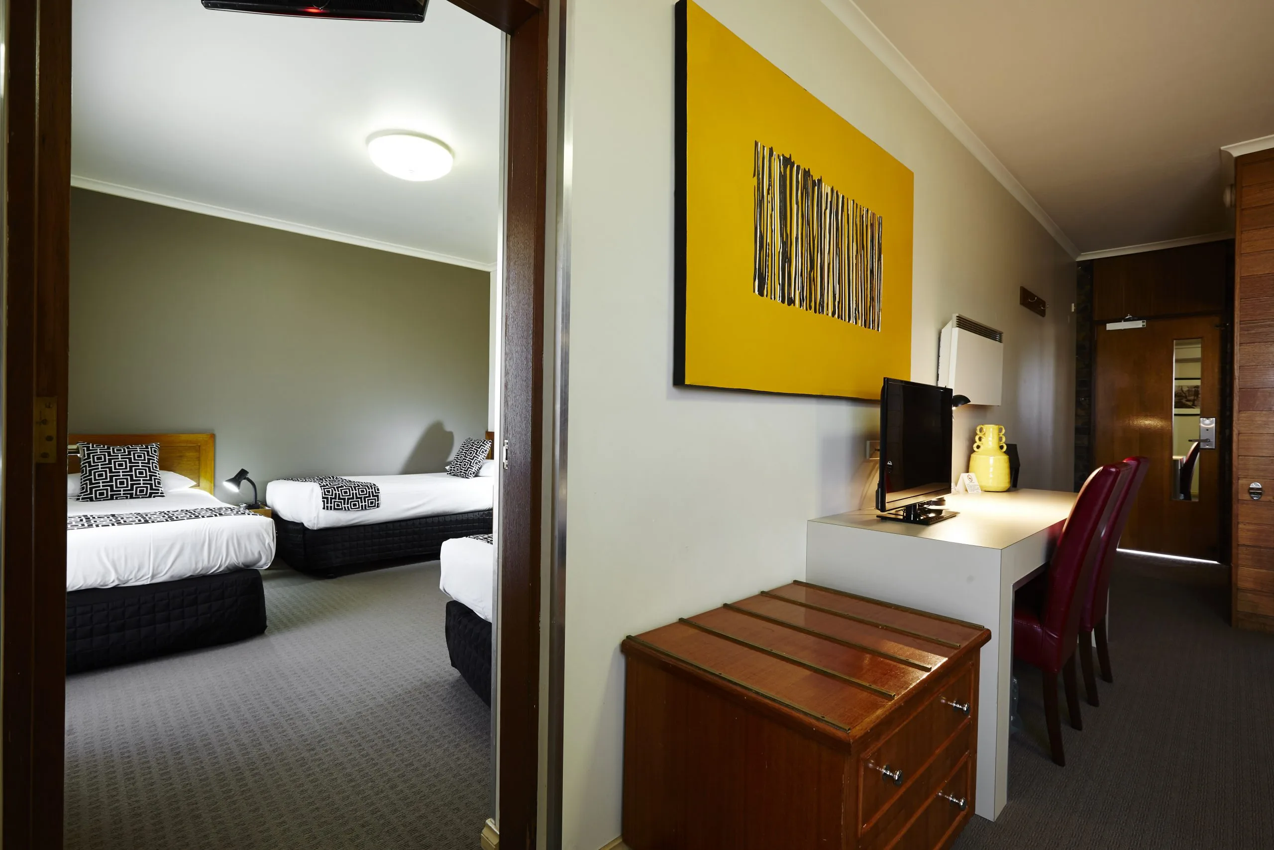 The two-bedroom unit has twin beds, a television and a work desk.