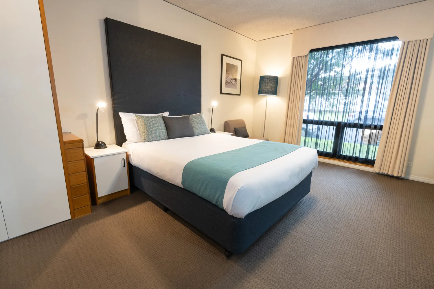 A neatly made bed in a guest room at Sovereign Park Motor Inn.