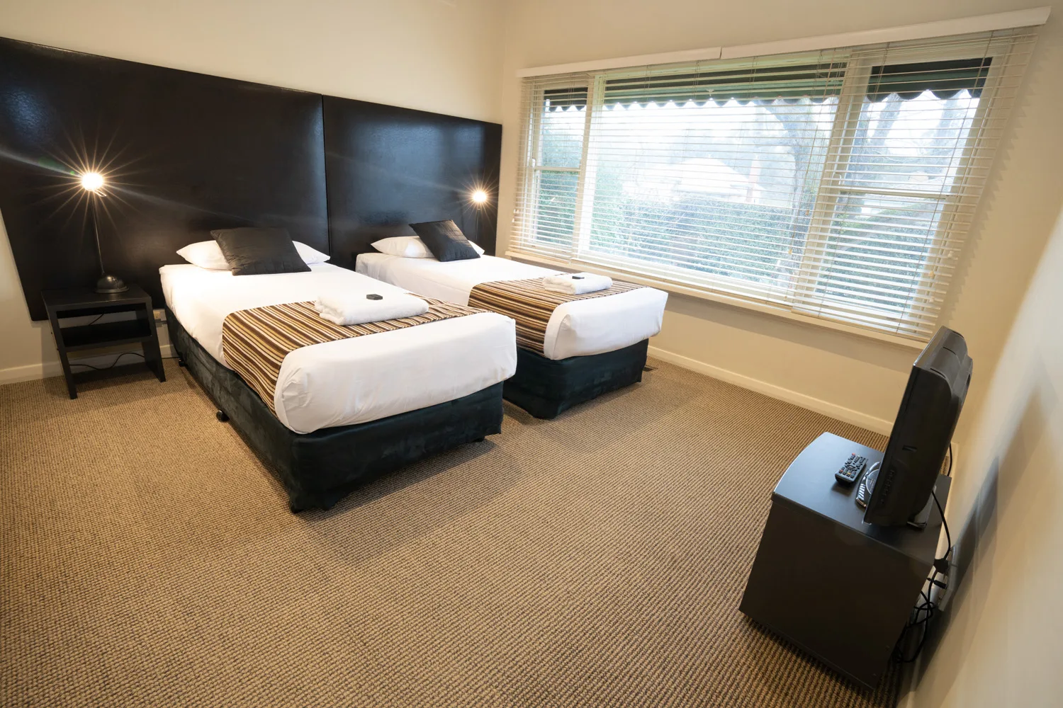 Twin bedroom at Residence on Main with two beds and a television.