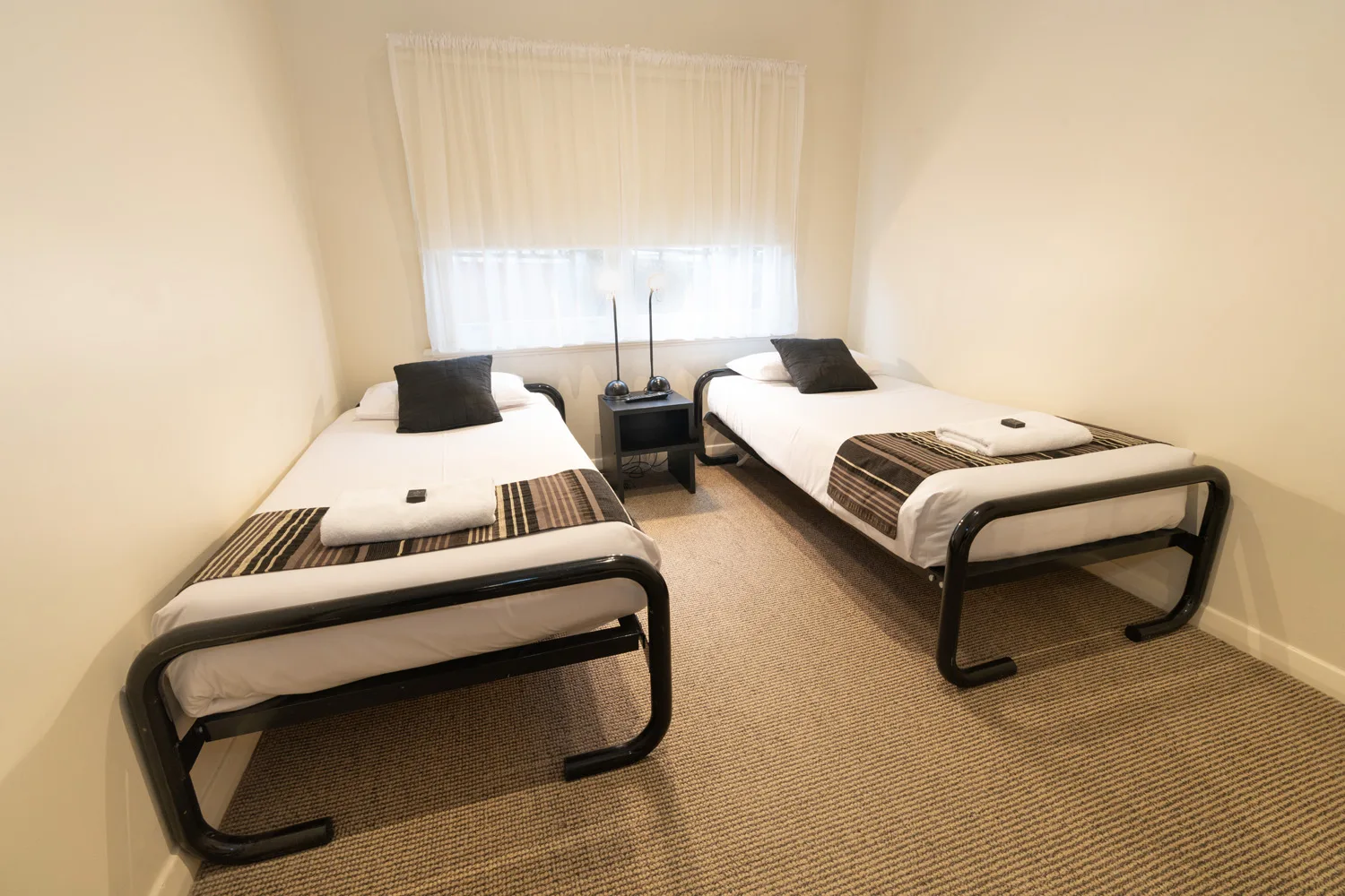Second bedroom at Residence on Main with two single beds.
