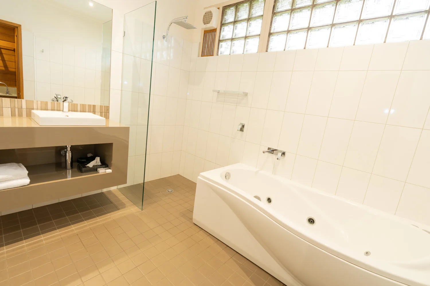 Executive spa bathroom with a jetted bath, glass shower and vanity.