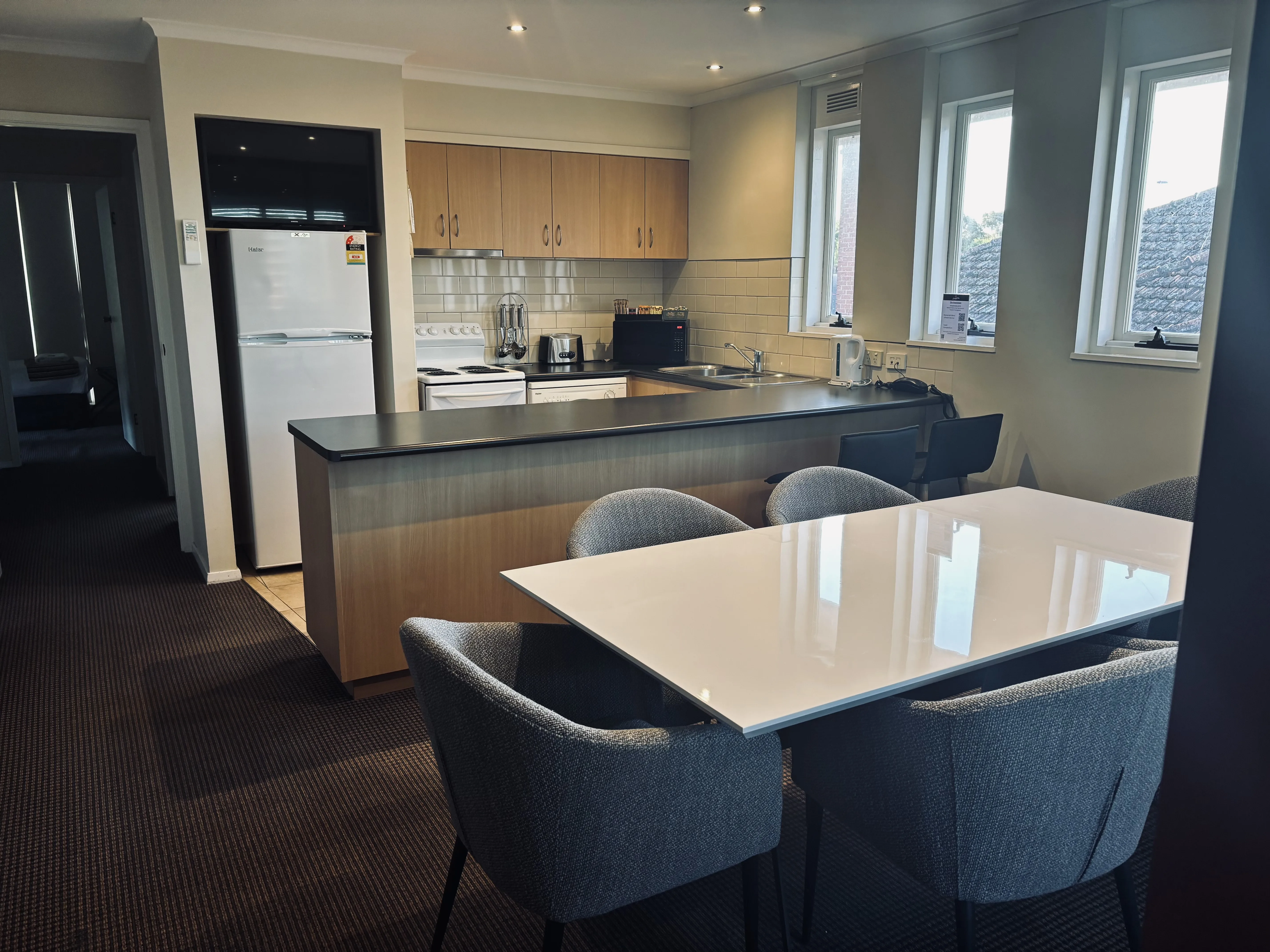A self-contained apartment has a fitted kitchen beside its lounge and dining area.