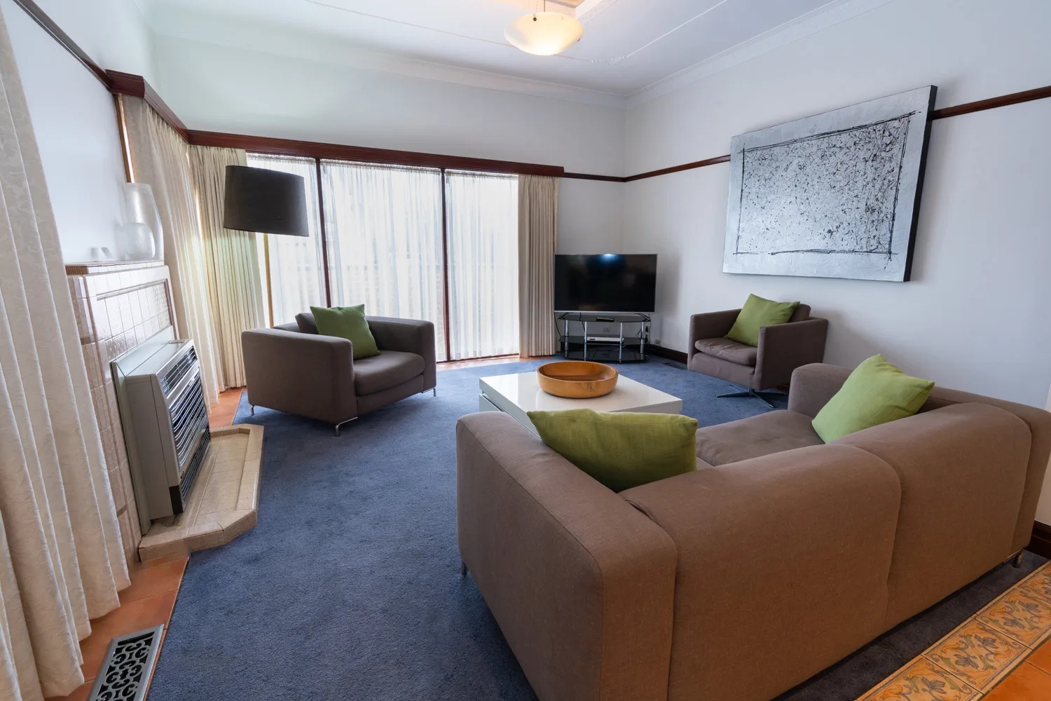 York House second lounge with sofas, a television and a wall heater.