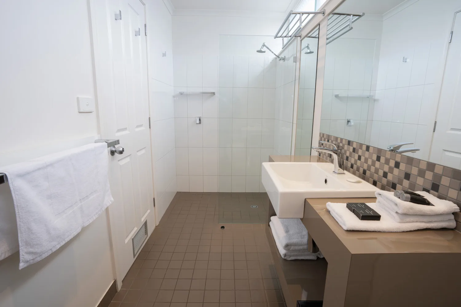 Bathroom in a Standard Unit with a walk-in shower, vanity and towels.