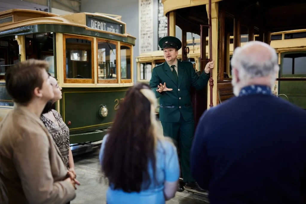 A guide shows visitors a historic tram at the Ballarat Tramway Museum.
