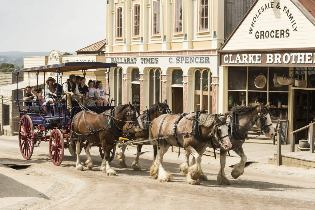 A horse-drawn coach passes historic shopfronts at Sovereign Hill, Ballarat.